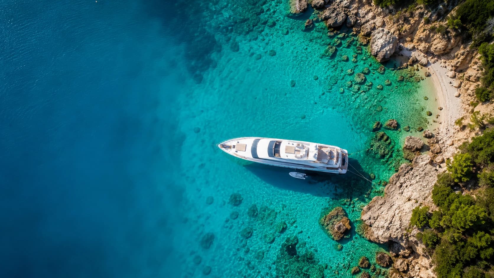 Aerial view of a yacht anchored in a hidden cove
